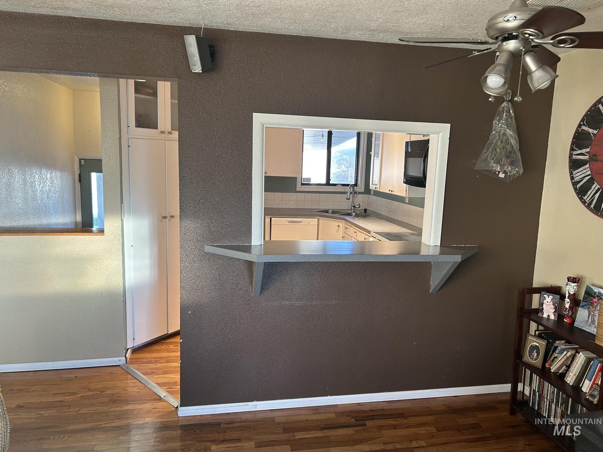 3731 16th Street Lewiston, ID 83501 - Photo 16 of 35 Kitchen with a kitchen bar, dark countertops, white dishwasher, dark wood-type flooring, and ceiling fan