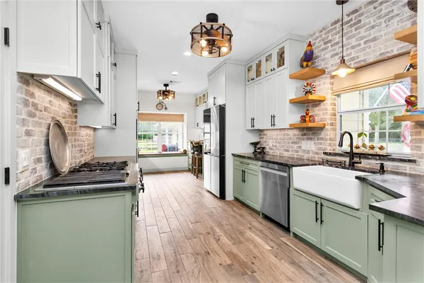 a kitchen with a stove a sink and cabinets