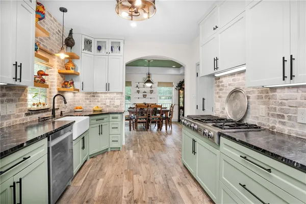 a kitchen with stainless steel appliances granite countertop a stove a sink and a refrigerator