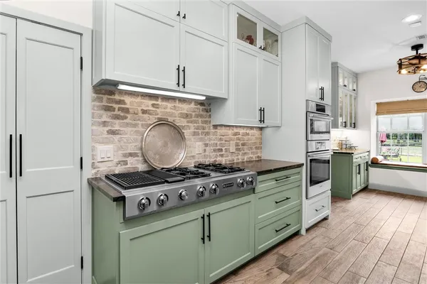 a kitchen with stainless steel appliances kitchen island granite countertop a table and chairs in it