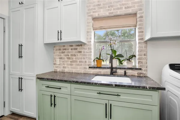a kitchen with a sink a stove cabinets and a window