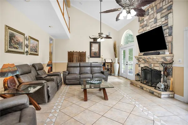a living room with couches chairs and chandelier