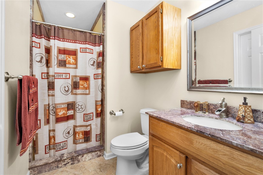 30820 Collier Smith Road Magnolia, TX 77354 - Photo 33 of 50 a bathroom with a sink a toilet and shower curtain