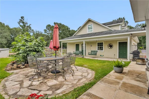 a view of a house with backyard porch and sitting area