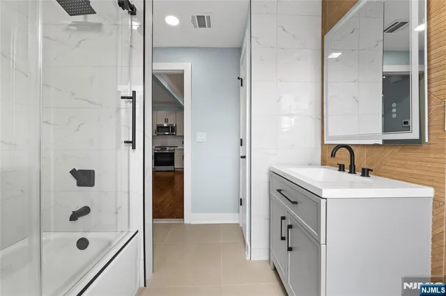 a bathroom with a bathtub toilet sink vanity and windows