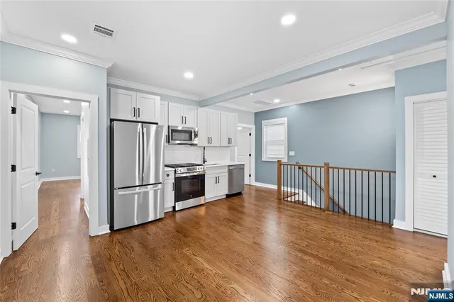 a kitchen with granite countertop a refrigerator and a stove top oven