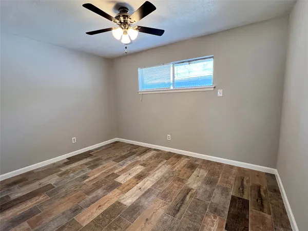 a view of an empty room with a chandelier fan
