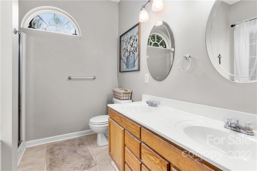 3505 Crow Burk Road Pageland, SC 29728 - Photo 24 of 30 a bathroom with a toilet a sink a mirror and a window