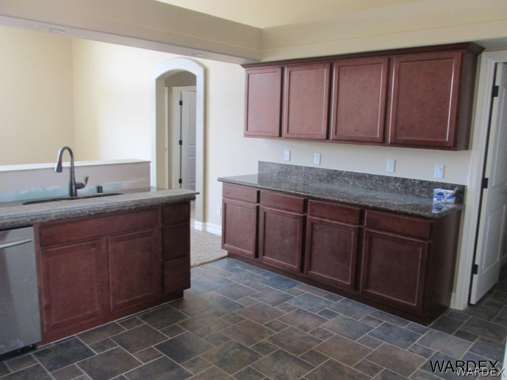 4939 North Neal Ranch Road Kingman, AZ 86401 - Photo 3 of 17 a kitchen with stainless steel appliances granite countertop a sink stove and cabinets