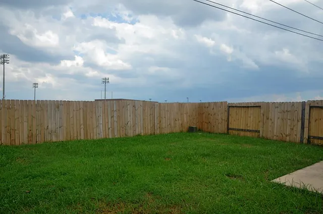 a view of a backyard with a fence