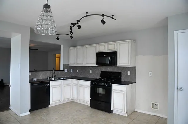 a kitchen with a sink and stove top oven