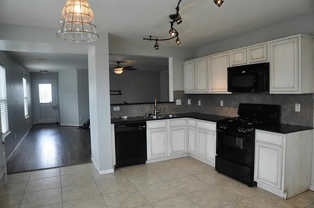 a kitchen with granite countertop a stove sink and cabinets
