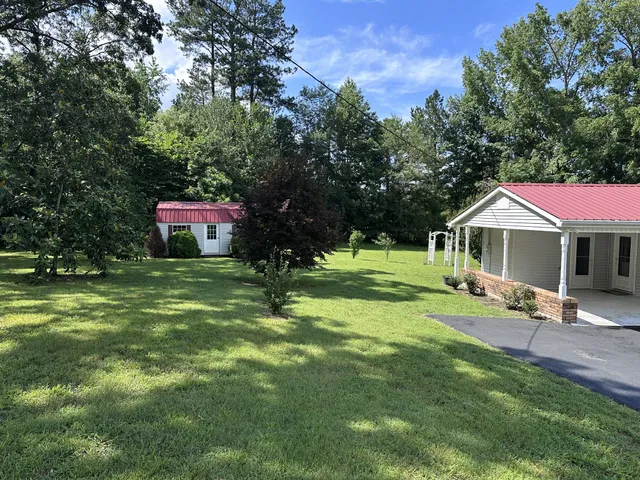 a front view of a house with a garden and trees