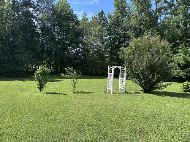 a house with green field in front of it