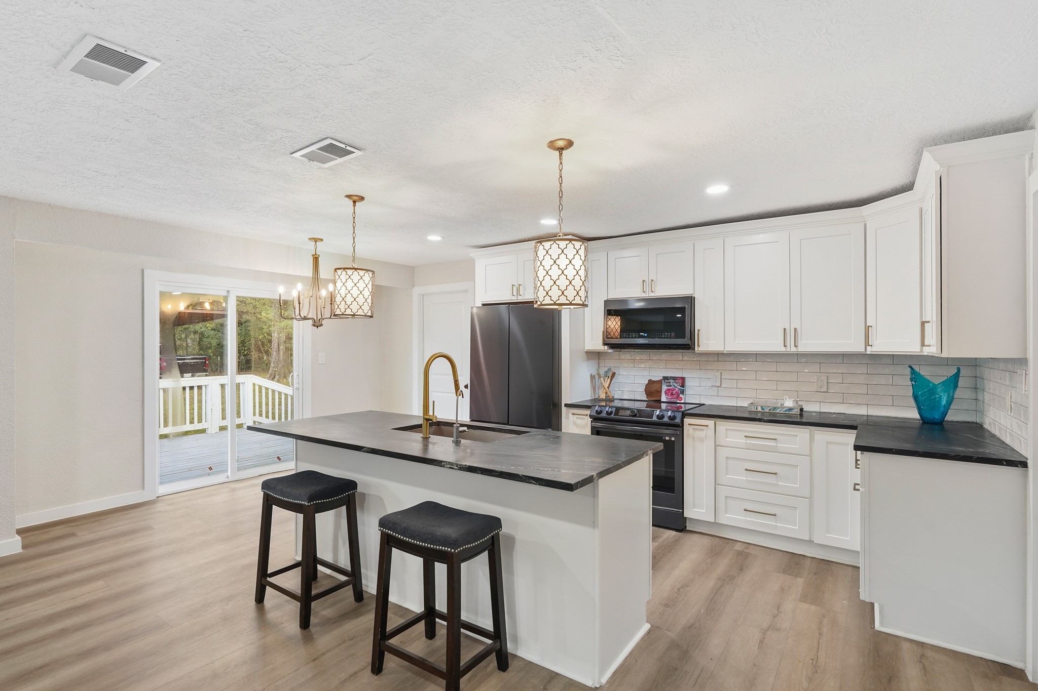 24006 Crooked Creek Road Hockley, TX 77447 - Photo 8 of 25 a kitchen with stainless steel appliances granite countertop a sink a stove a microwave and wooden floors