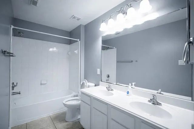 a bathroom with a double vanity sink toilet mirror and bathtub
