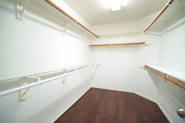 a view of walk in closet with empty racks