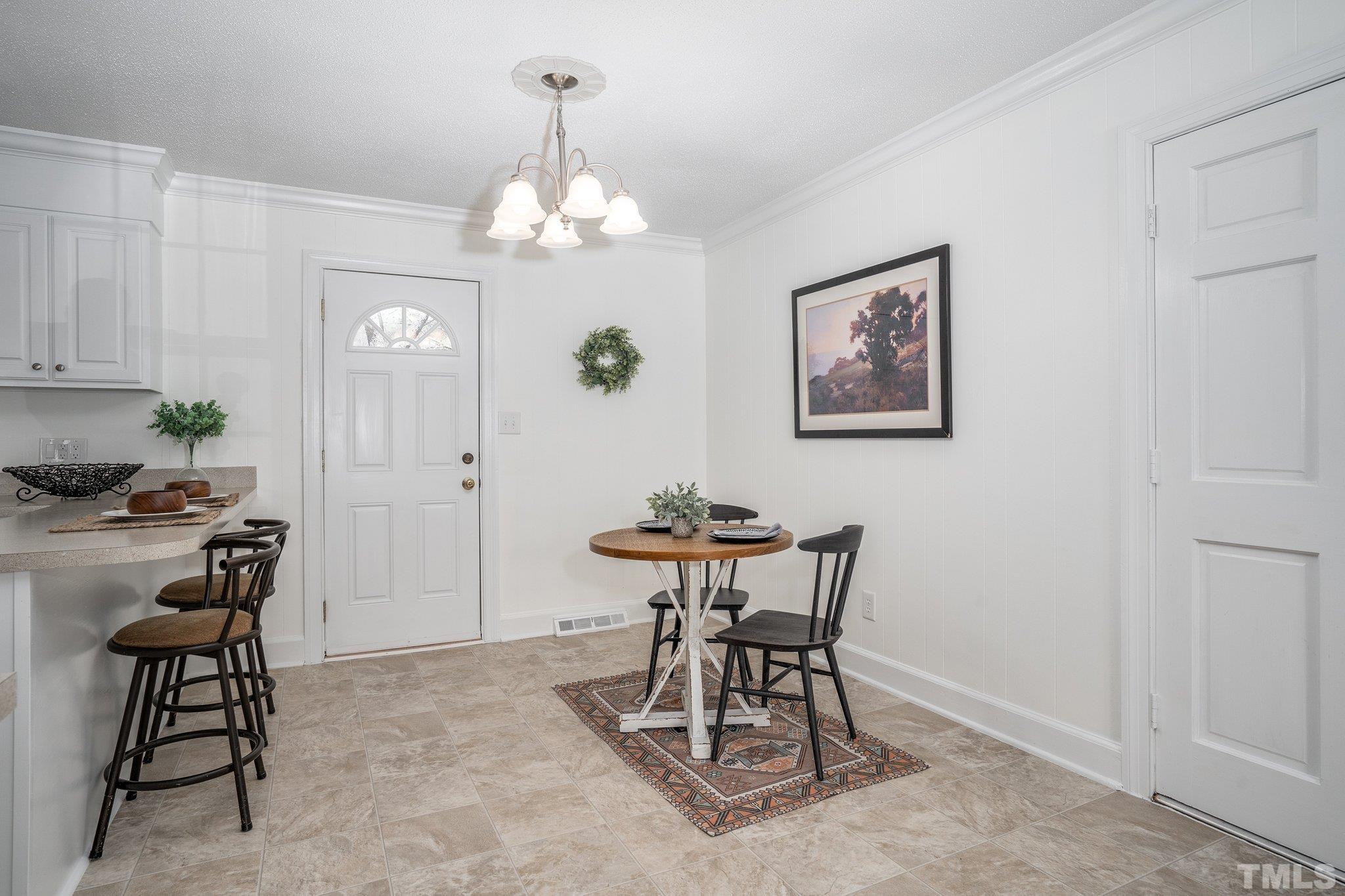 1106 Raleigh Rd Parkway West Wilson, NC 27896 - Photo 8 of 22 a view of a dining room with furniture a chandelier and wooden floor