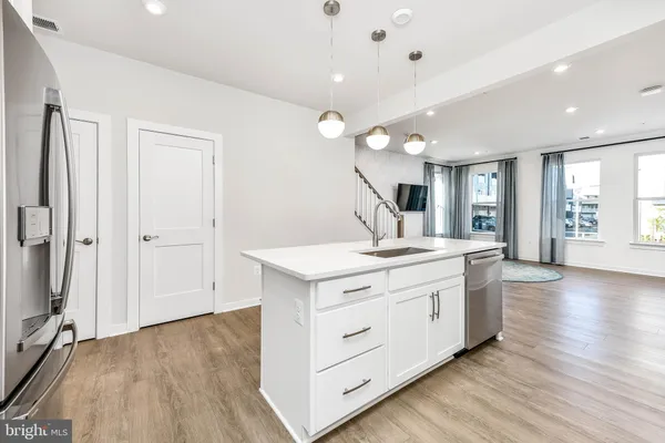 a kitchen with a stove and wooden floor