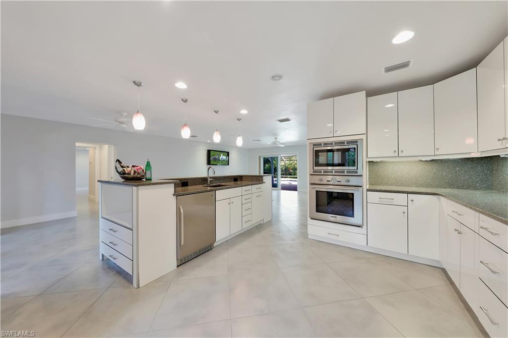 451 Rudder Road Naples, FL 34102 - Photo 13 of 25 a large white kitchen with stainless steel appliances