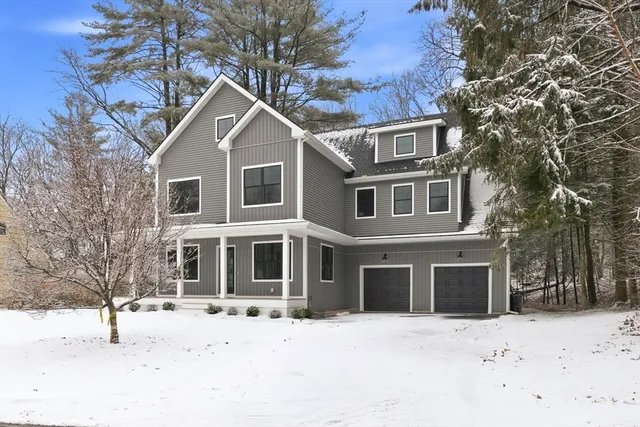 a front view of a house with a yard covered in snow