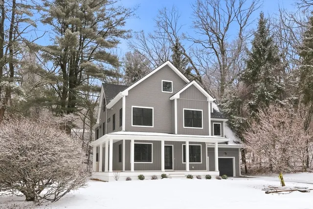 a front view of a house with a yard covered with snow
