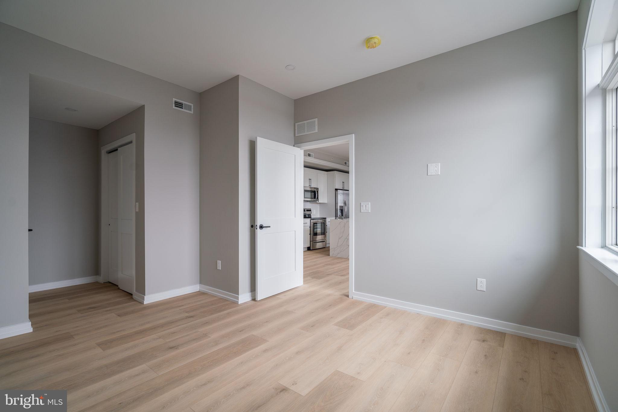 2401 Washington Avenue, Unit 5D Philadelphia, PA 19146 - Photo 13 of 18 a view of an empty room with wooden floor and windows