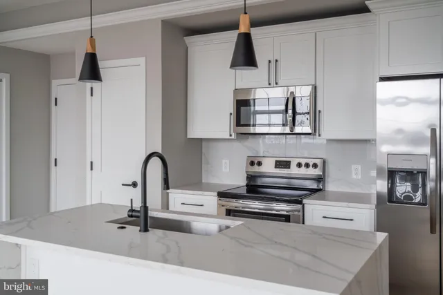 a kitchen with stainless steel appliances a sink a stove and a wooden floors