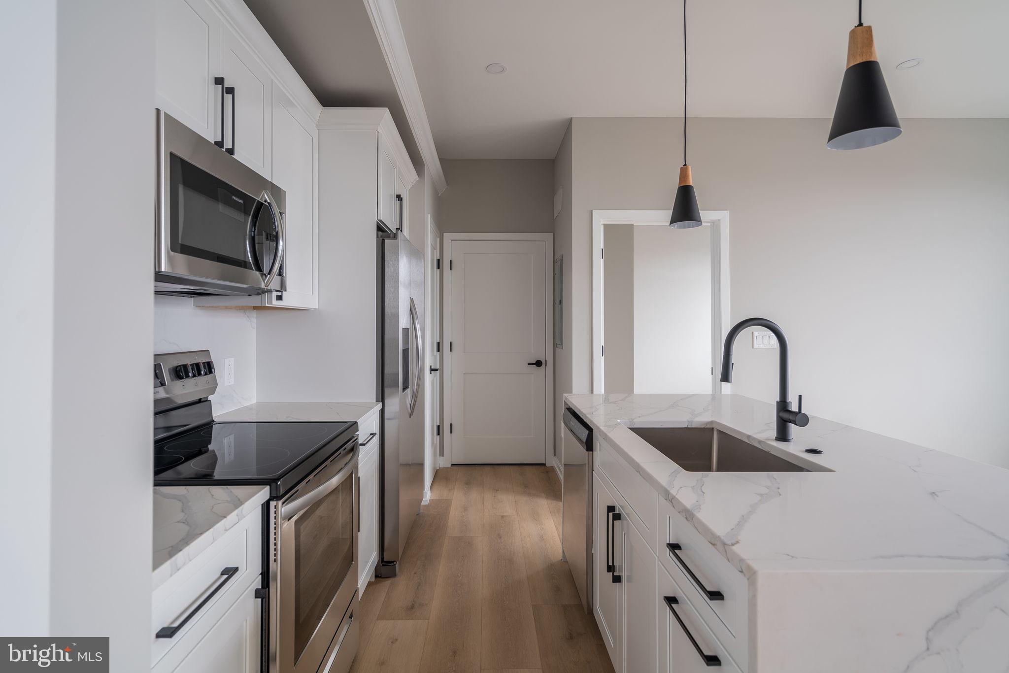 2401 Washington Avenue, Unit 5D Philadelphia, PA 19146 - Photo 5 of 18 a kitchen with stainless steel appliances granite countertop a sink a stove and a refrigerator