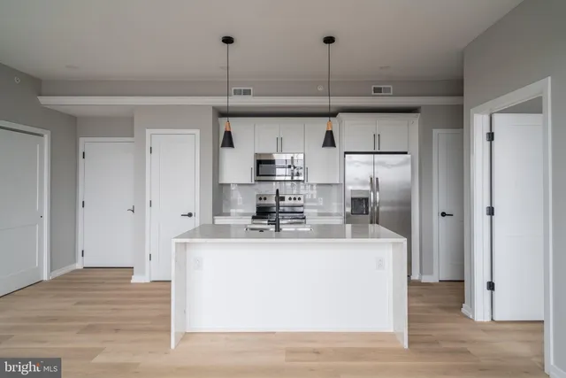 a view of kitchen with stainless steel appliances granite countertop refrigerator sink and cabinets