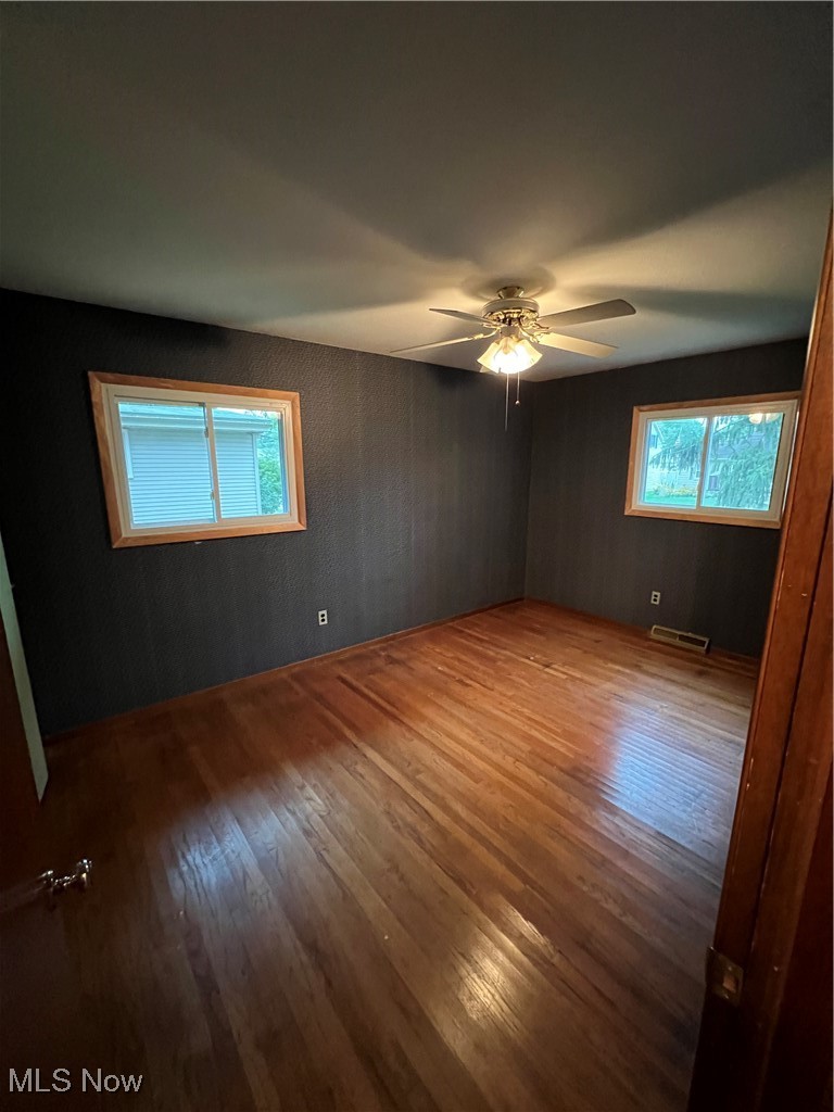 218 Nobottom Road Berea, OH 44017 - Photo 7 of 14 Empty room with hardwood / wood-style floors, healthy amount of natural light, and ceiling fan