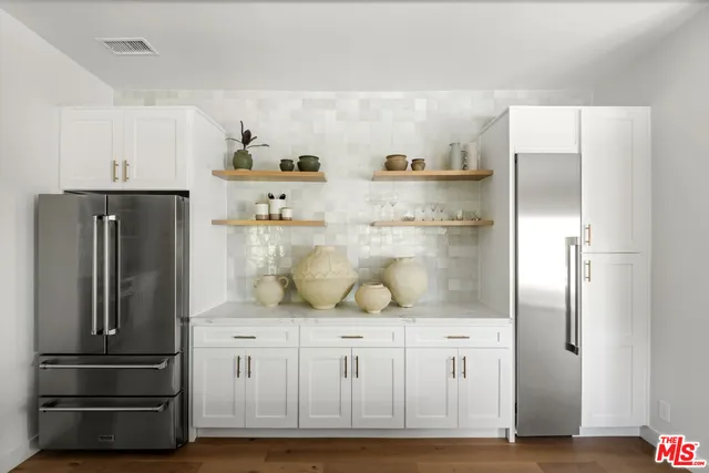 a kitchen with white cabinets and refrigerator