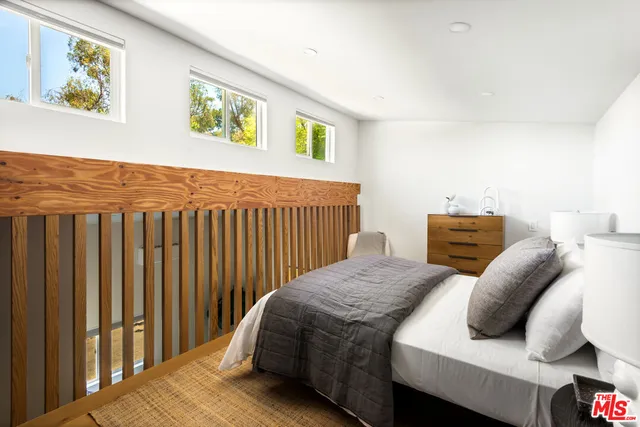 a bed sitting in a bedroom next to a window