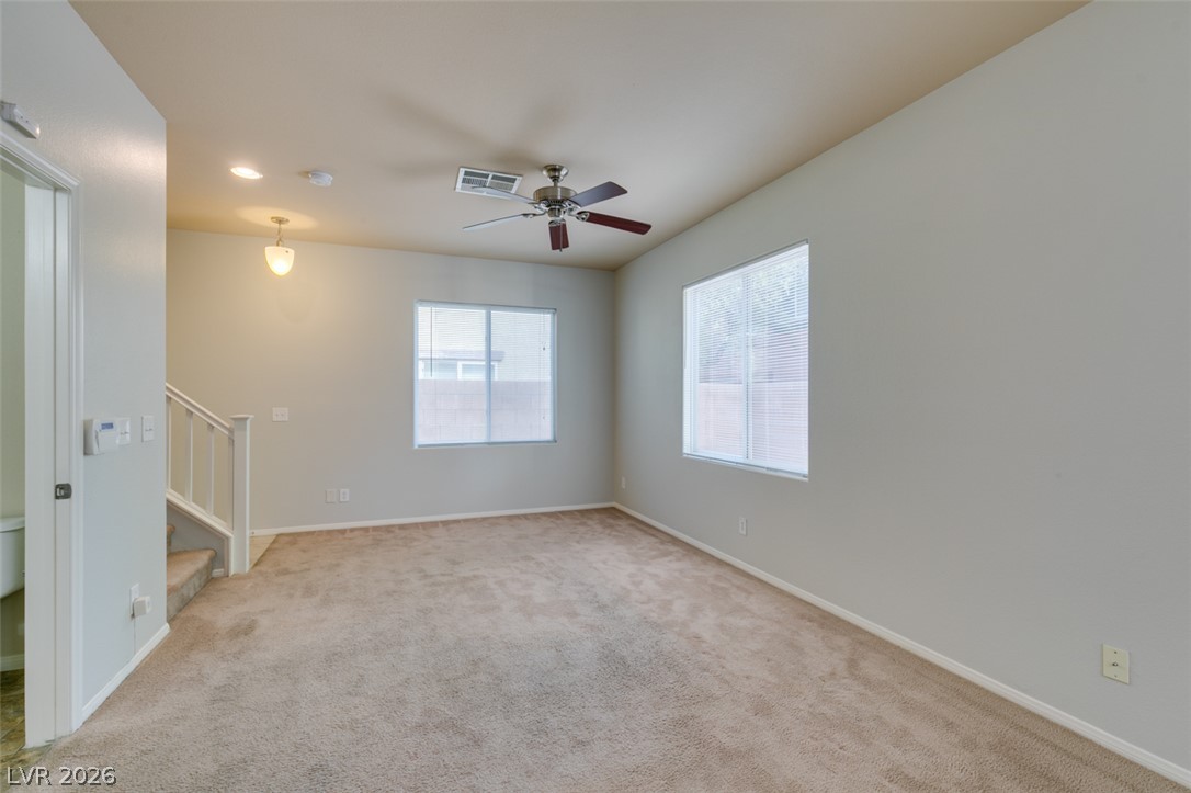 8937 Caledon Ridge Court Las Vegas, NV 89149 - Photo 6 of 43 Well-lit living room, featuring cozy carpet and a ceiling fan for comfort.