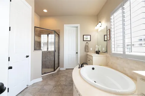 a bathroom with a white bath tub sitting next to a window