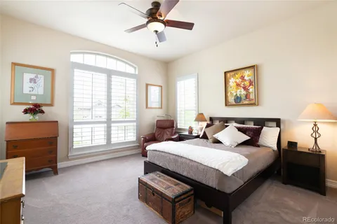 a spacious bedroom with a bed a dresser and a window