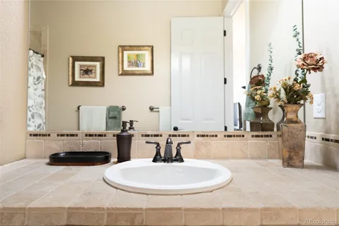 a bathroom with a granite countertop sink and a mirror