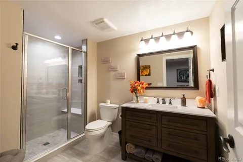 a bathroom with a toilet a sink and glass door