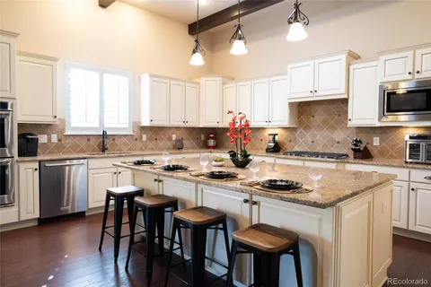 a kitchen with granite countertop white cabinets and white appliances