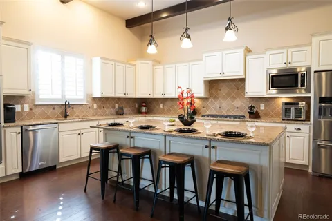 a kitchen with white cabinets and chairs