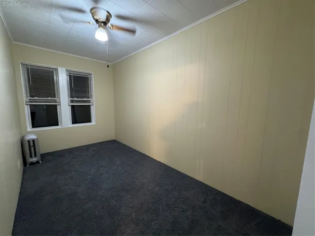 an empty room with a ceiling fan and a window