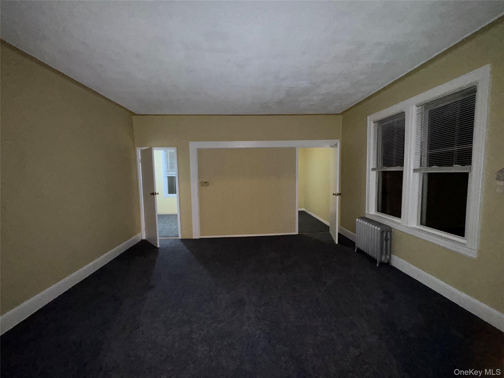 40-13 201st Street Queens, NY 11361 - Photo 5 of 16 an empty room with windows