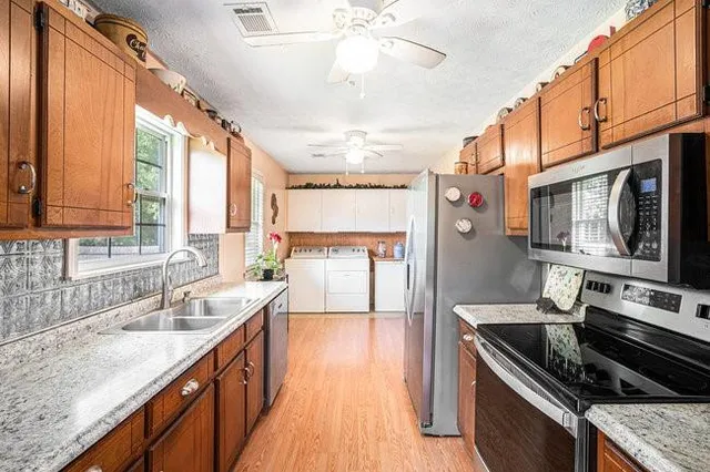 a kitchen with stainless steel appliances granite countertop a sink stove and refrigerator