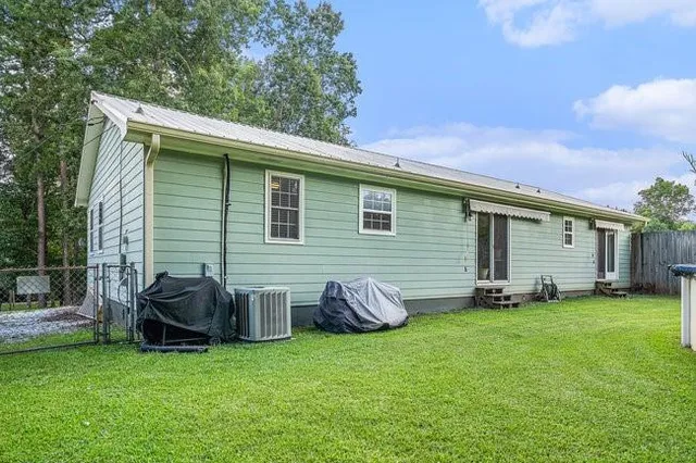 a view of a backyard with potted plants and a large tree