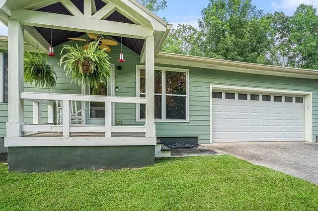 a front view of a house with a garden and plants