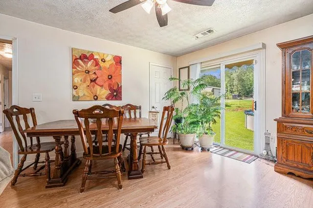 a view of a dining room with furniture a chandelier and wooden floor