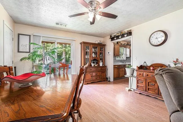 a view of a dining room with furniture a chandelier and wooden floor