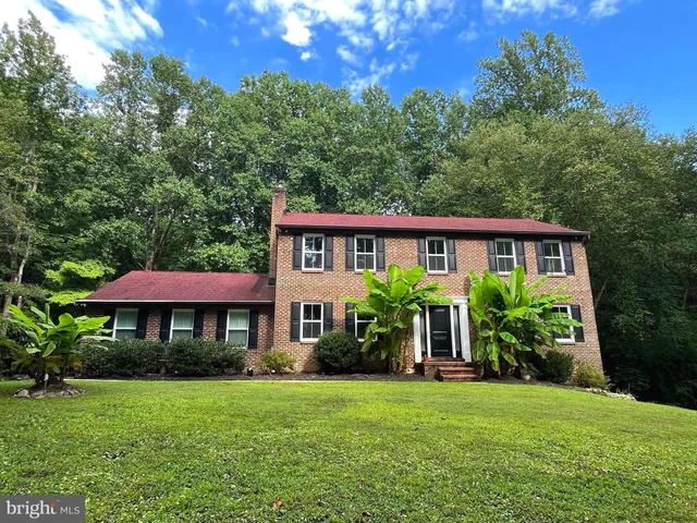 a front view of a house with yard and green space