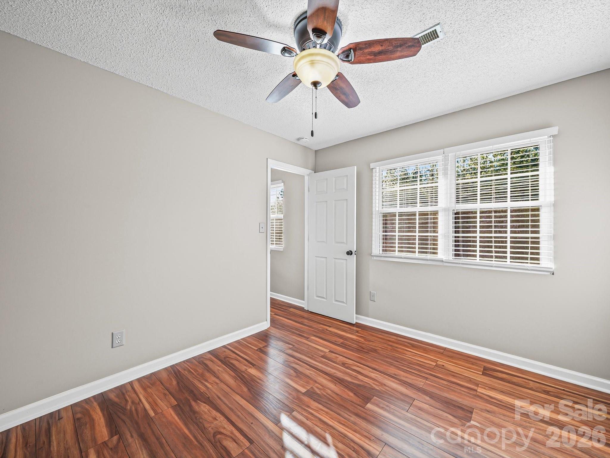10351 Fink Road Mount Pleasant, NC 28124 - Photo 14 of 20 a view of an empty room with window and wooden floor