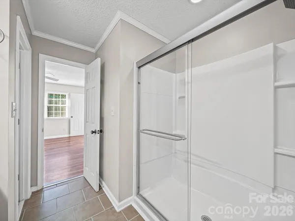 a bathroom with a shower and a glass door